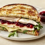 Turkey cranberry sandwich with melted brie and fresh arugula on toasted sourdough