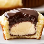 Close-up of a Boston Cream Cupcake with a creamy custard filling and a smooth chocolate ganache topping, highlighting its rich texture and delicious layers.