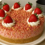 Close-up of strawberry crunch cheesecake with whipped cream and fresh strawberries